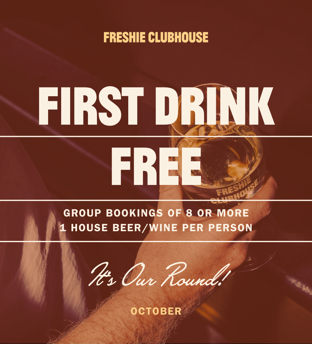 Prompotional poster for Freshie Clubhouse advertising a free first drink for group bookings of 8 or more, with one house beer or wine per person. Features a dark moody cocktail background with bold white text, the slogan "It's Our Round!" and the month of October.